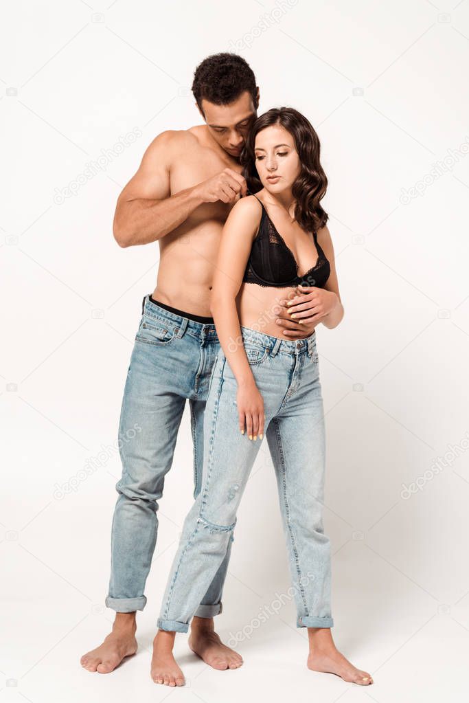 sexy mixed race man touching black bra of attractive girl on white 