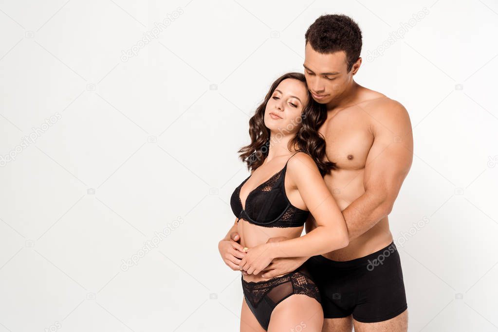 sexy mixed race man looking at attractive woman in black underwear isolated on white 