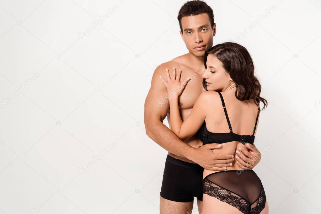 handsome mixed race man hugging sexy woman isolated on white 