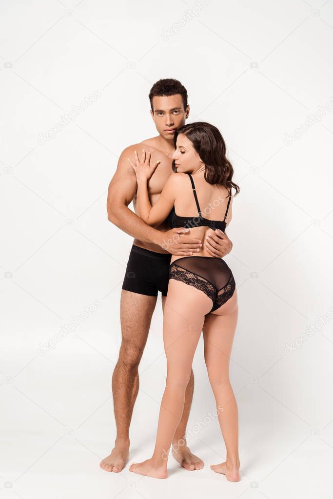 handsome mixed race man hugging sexy young woman on white 