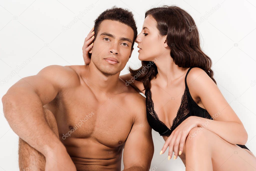 attractive woman looking at handsome shirtless bi-racial man isolated on white 