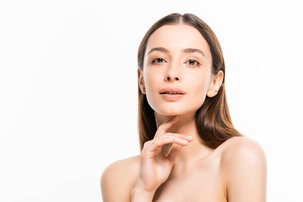 красивая молодая голая женщина с идеальной кожей, глядя в камеру, касаясь подбородка изолированы на белом
