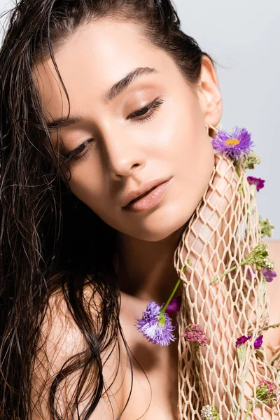 美丽的女人与湿头发在网格与紫色的花朵构成孤立的灰色 — 图库照片