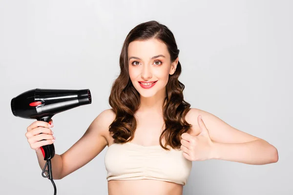 Beautiful Brunette Woman Curls Makeup Holding Hairdryer Showing Thumb Isolated — Stock Photo, Image