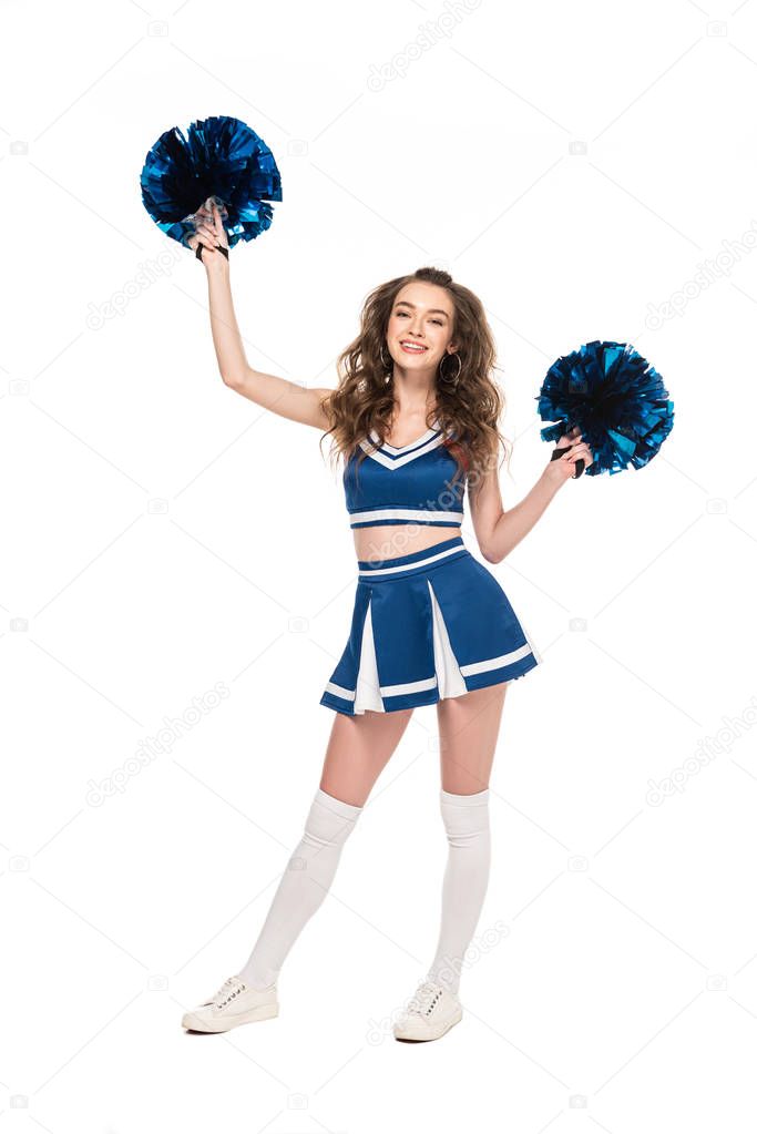 full length view of happy cheerleader girl in blue uniform dancing with pompoms isolated on white