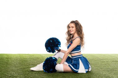 side view of sexy happy cheerleader girl in blue uniform with pompoms on green field isolated on white clipart