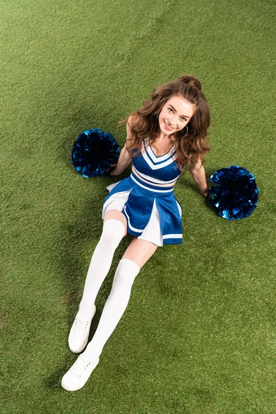 Overhead View Pretty Cheerleader Girl Blue Uniform Lying Pompoms Green — Stock Photo, Image
