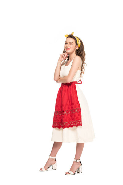 full length view of happy young housewife in dress and apron posing isolated on white