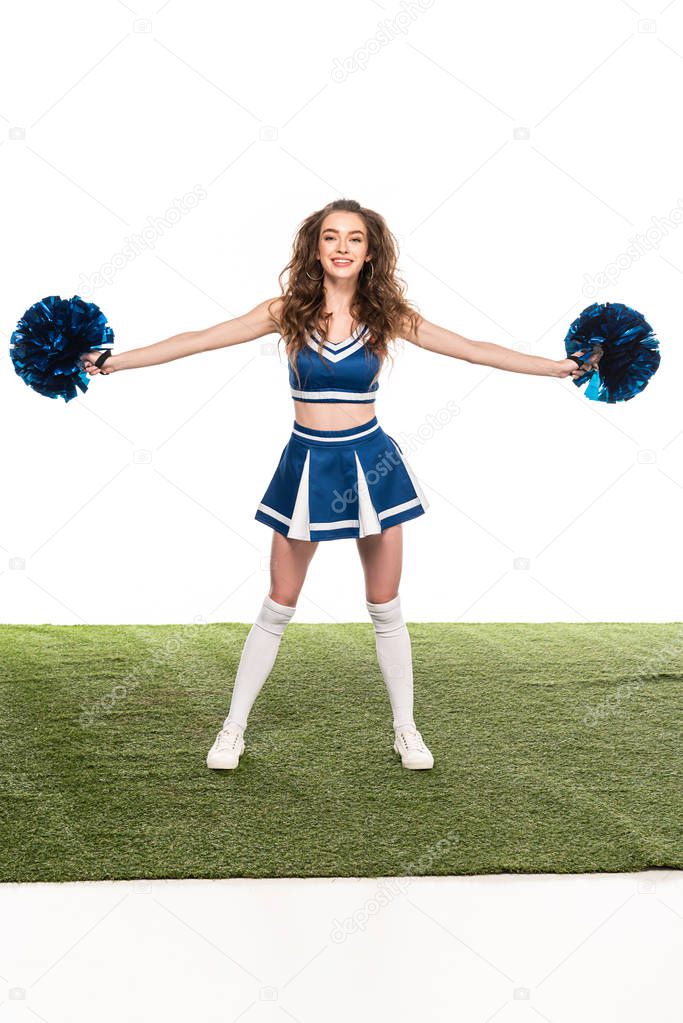 sexy happy cheerleader girl in blue uniform with pompoms on green carpet isolated on white