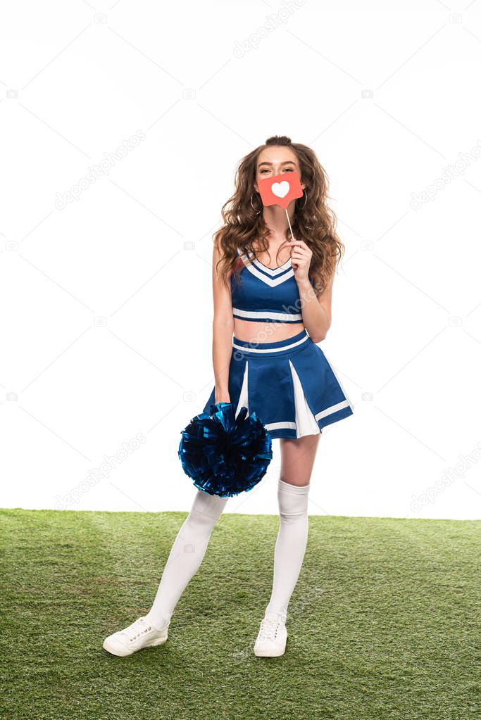 cheerleader girl in blue uniform with like sign and pompom on green field isolated on white