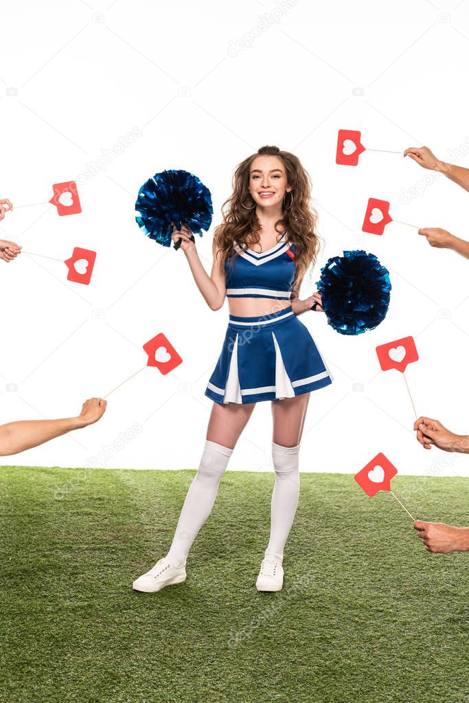 cheerleader girl in blue uniform with pompoms standing on green field with people hands holding likes around isolated on white