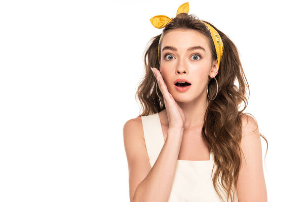 young shocked housewife in dress and headband looking at camera isolated on white