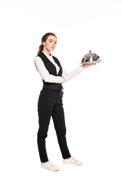 full length view of young waitress in formal wear holding dish on plate isolated on white