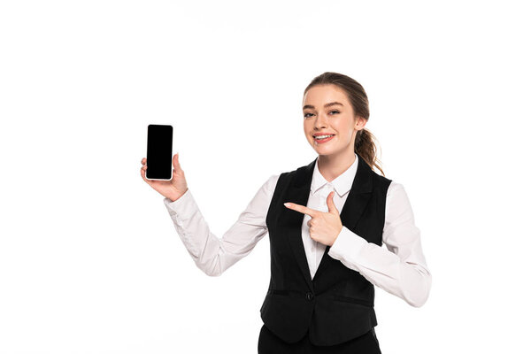 happy young waitress pointing with finger at blank screen on smartphone isolated on white