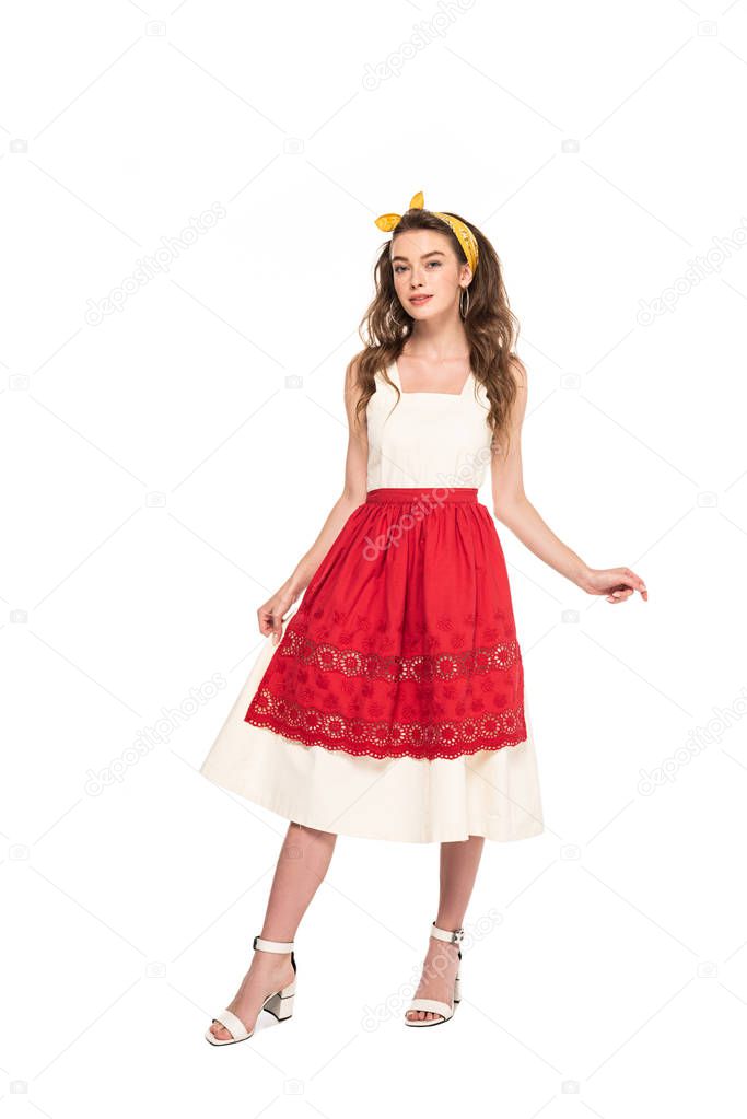 full length view of young housewife in dress and apron isolated on white