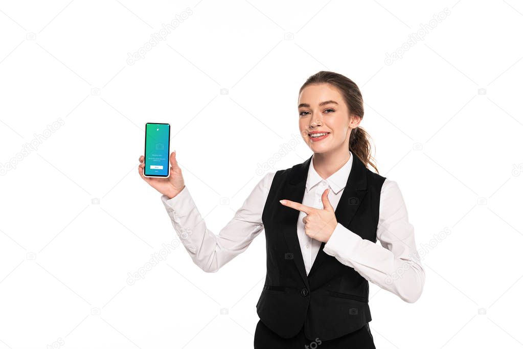 KYIV, UKRAINE - APRIL 7, 2019: happy young waitress pointing with finger at twitter app on smartphone isolated on white