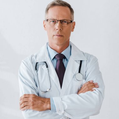 Çapraz kollar ile stetoskop ayakta ve kamera bakarak yakışıklı Doktor 