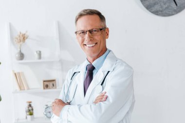 happy doctor in white coat and glasses with crossed arms  clipart