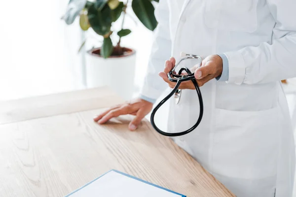 Cropped View Doctor Holding Stethoscope Wooden Table — Stock Photo, Image