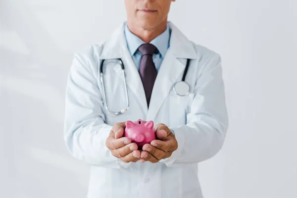 Visão Recortada Médico Segurando Banco Piggy Rosa Nas Mãos Branco — Fotografia de Stock