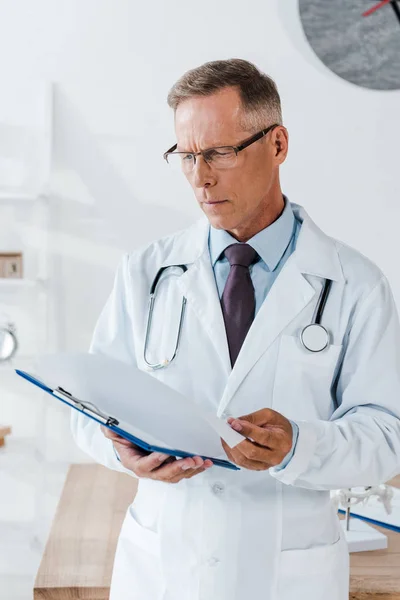 Handsome Doctor White Coat Looking Clipboard Hospital — Stock Photo, Image