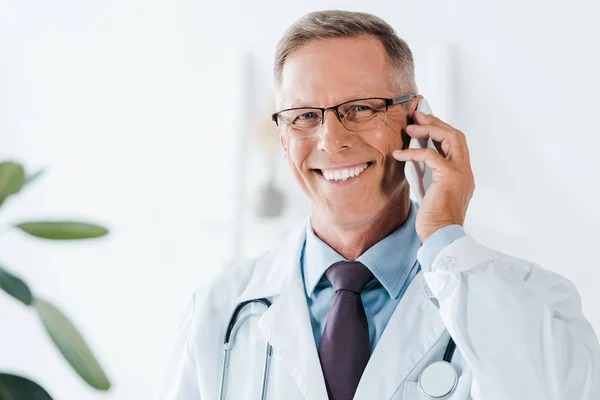 Médico Feliz Olhando Para Câmera Falando Smartphone Clínica — Fotografia de Stock