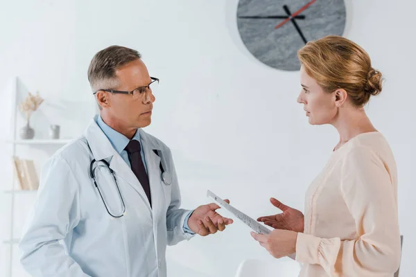 Doctor Glasses Gesturing Woman Holding Clipboard — Stock Photo, Image