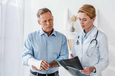 çekici Doktor kırık kol ve x-ışını bakarak adam yakın işaret 