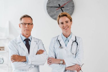 Klinikte neşeli meslektaşım yakın çapraz silah ile gözlük ayakta doktor 