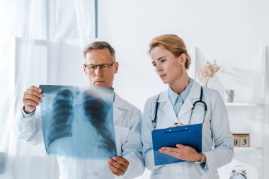 çekici Doktor holdıng Clipboard ve bakarak x-ray yakın iş arkadaşı 