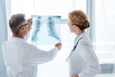 Doktor x-ışın klinikte beyaz ceket ayakta meslektaşı yakın bakıyor 