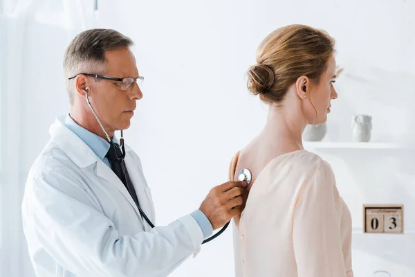 Médico Bonito Óculos Examinando Mulher Clínica — Fotografia de Stock