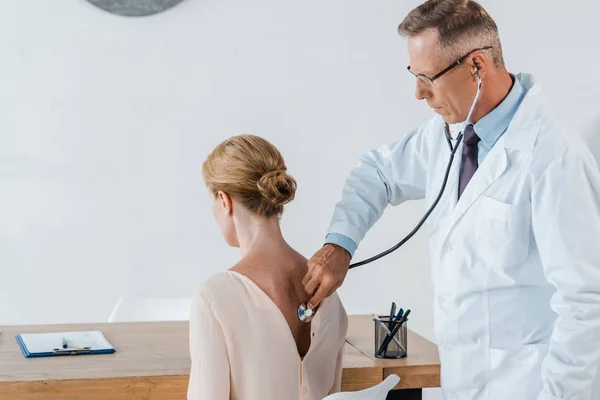Doktor Brýlích Použitím Stetoskop Při Zkoumání Ženy Klinice — Stock fotografie