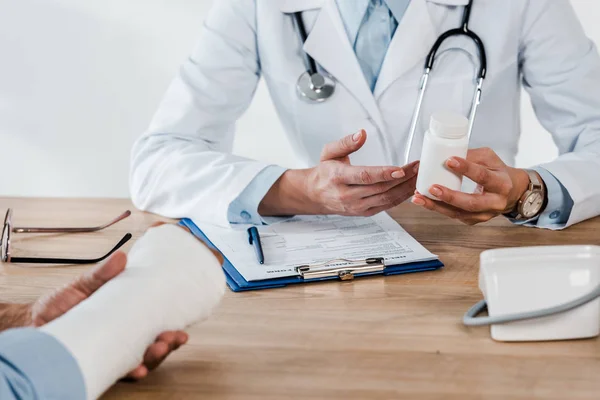 Cropped View Doctor Holding Bottle Injured Patient — Stock Photo, Image