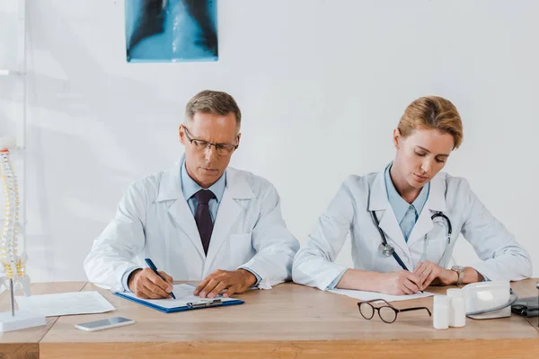 Schöner Arzt Und Attraktiver Mitarbeiter Schreibt Diagnose Klinik — Stockfoto