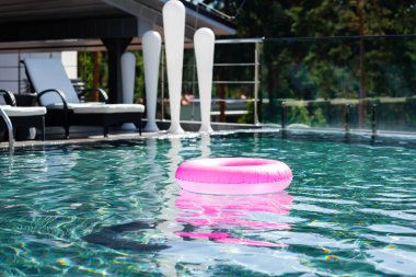 pink inflatable ring in swimming pool on resort during daytime clipart
