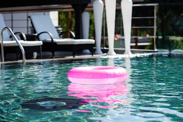 pink inflatable ring in swimming pool on resort during daytime