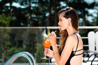tatil de kokteyl ile mayo içinde çekici kadın yan görünümü
