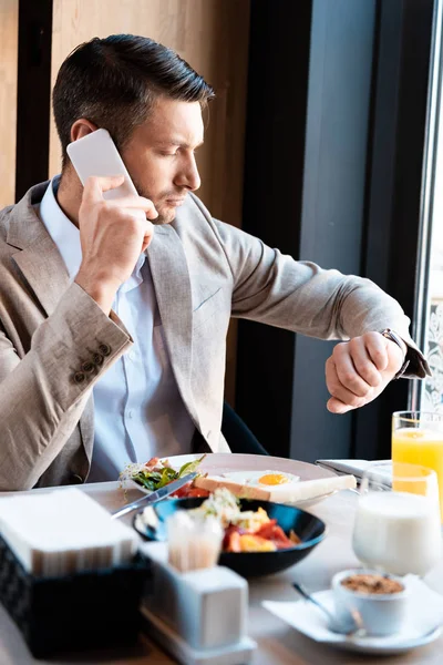 Affärsman Pratar Smartphone Och Tittar Watch Café — Stockfoto