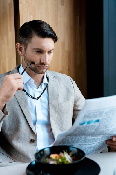 Empresario Enfocado Sosteniendo Gafas Leyendo Periódico Cafetería — Foto de Stock