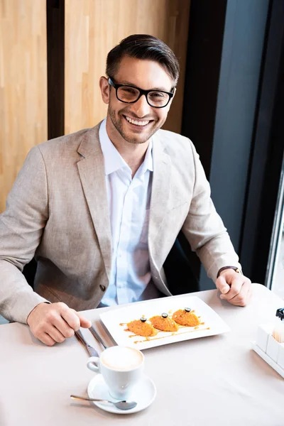 Lächelnder Geschäftsmann Gläsern Sitzt Tisch Mit Leckerem Gericht Café — Stockfoto