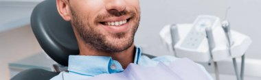 panoramic shot of happy patient smiling in dental clinic  clipart