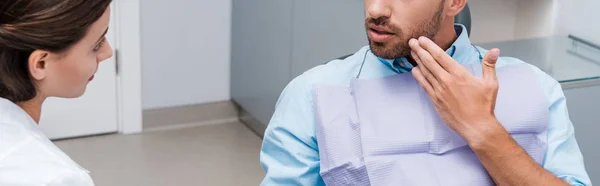 Tiro Panorâmico Homem Gesticulando Perto Dentista Atraente Clínica — Fotografia de Stock