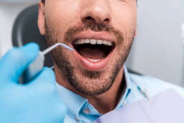 Przycięte Widok Kobiety Trzyma Instrument Dentystyczny Blisko Człowieka Otwartą Usta — Zdjęcie stockowe