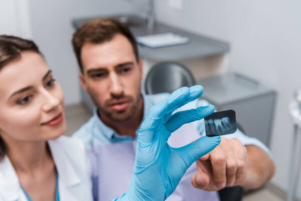 selective focus of x-ray near patient and attractive dentist 
