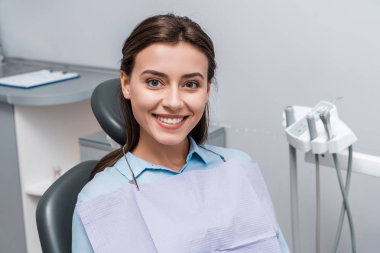beautiful woman sitting and smiling in dental clinic  clipart