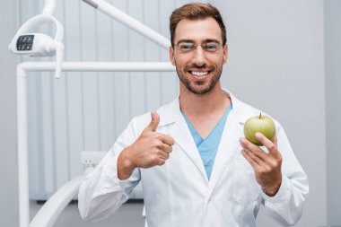 yeşil ve lezzetli elma tutan gözlük mutlu sakallı doktor ve başparmak gösteren 