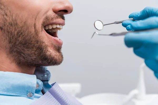 Visão Recortada Mulher Luvas Látex Segurando Instrumentos Dentários Perto Paciente — Fotografia de Stock