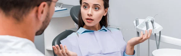 Panoramische Shot Van Tandarts Buurt Van Aantrekkelijke Vrouw Die Schouderophalend — Stockfoto