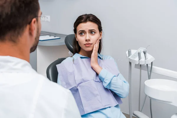 Selektywna Koncentracja Atrakcyjnej Smutnej Kobiety Mającej Ból Zębów Patrząc Dentystę — Zdjęcie stockowe